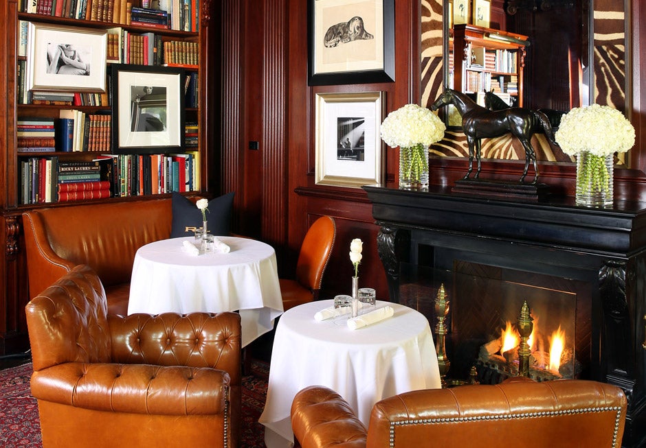 Tufted brown leather chair by fireplace & round tables