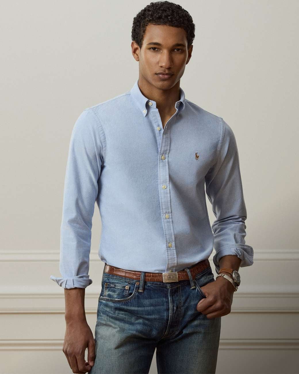 Man wears blue Slim Fit button-down shirt and jeans.